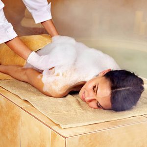 Young woman in hammam or turkish bath. Steam in bathroom.